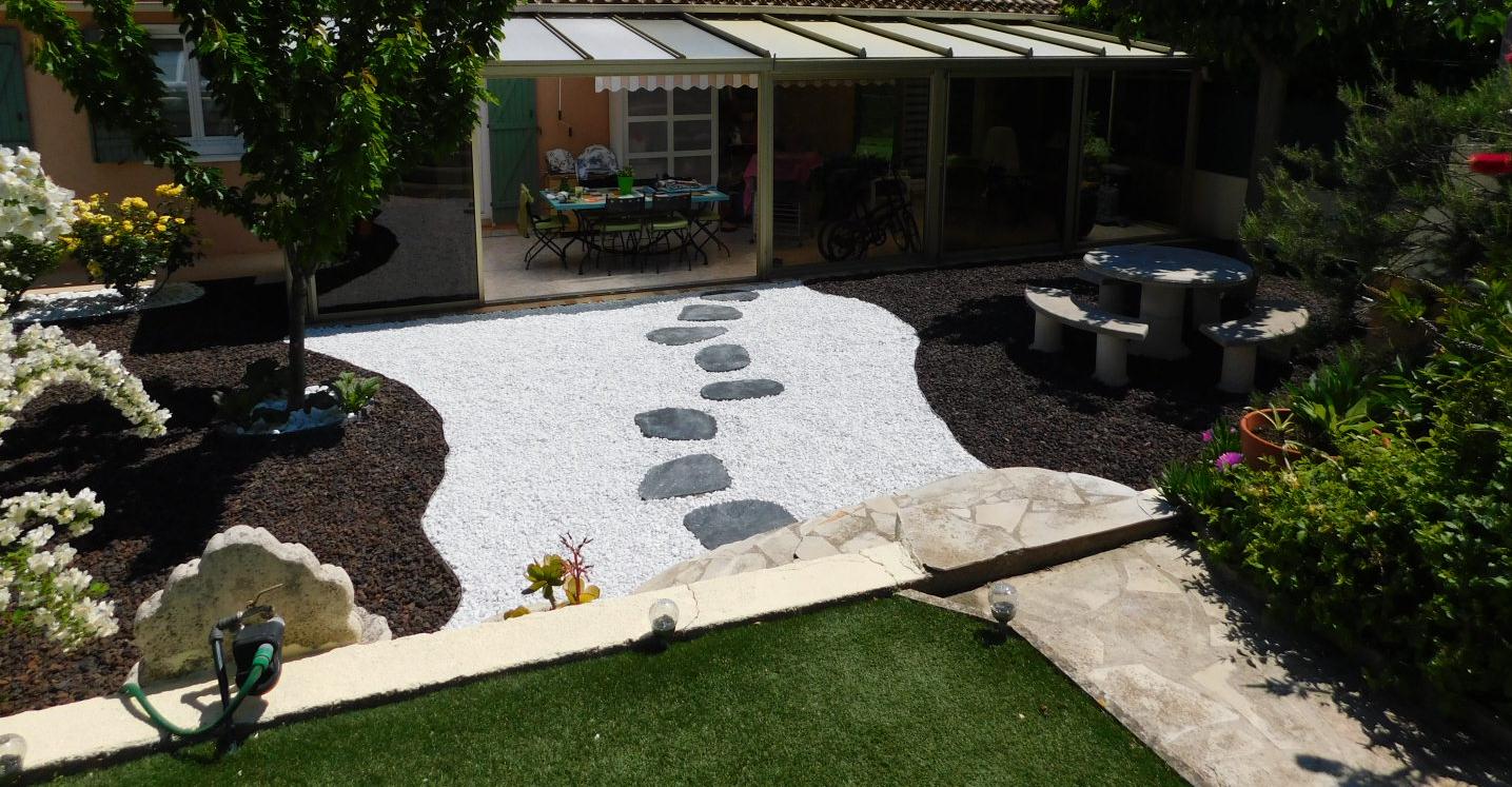 Jardin composé de pas japonais irréguliers en ardoise, galets blancs de carrare et pouzzolane