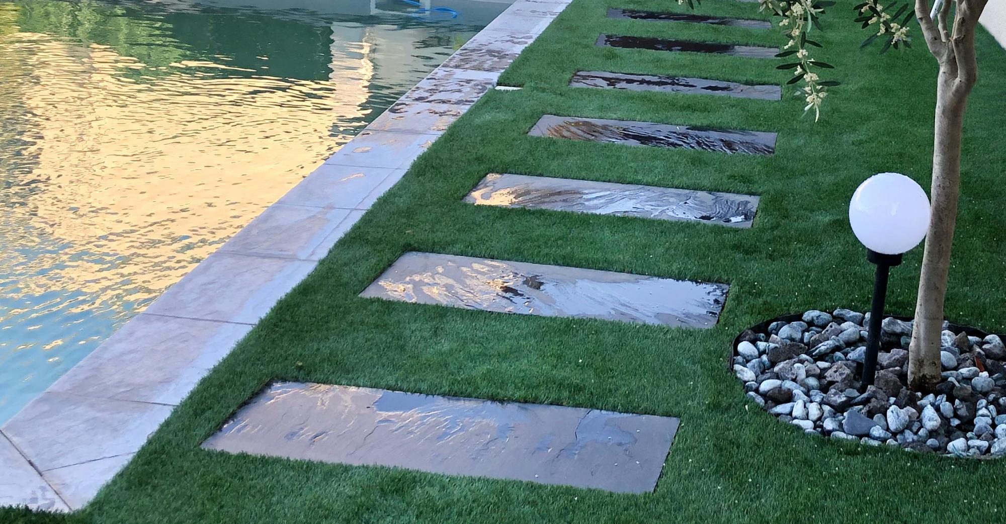 Plage de piscine en gazon synthétique et dalles en ardoise 